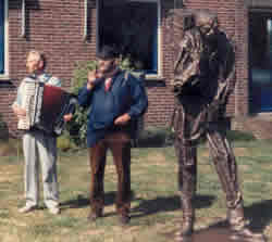 De Zwagers (George Petzinger in blauwe kiel) bij het beeld van de kiepkerel in Oude Pekela